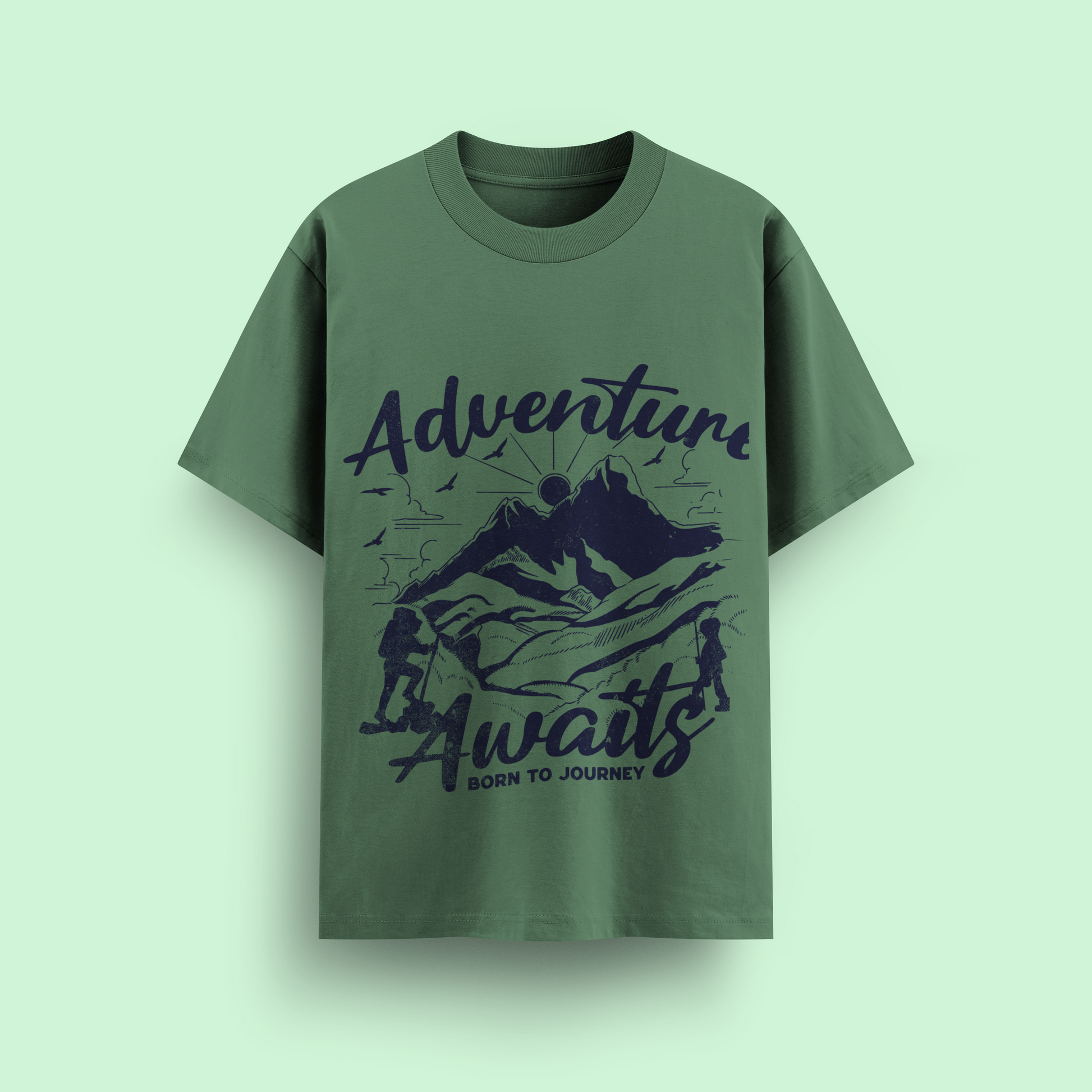 Green t-shirt with 'Adventure Awaits' graphic on a light green background
