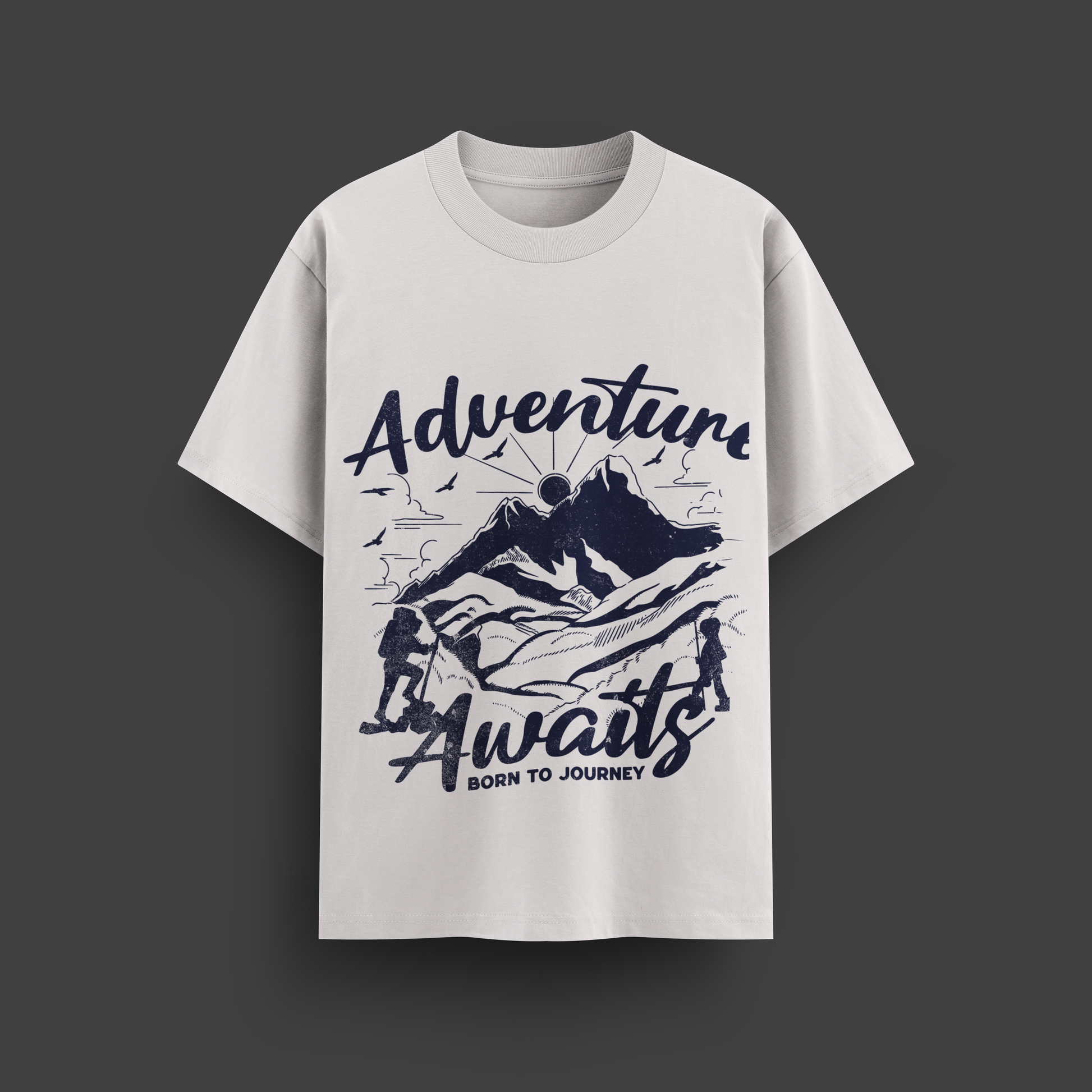 White t-shirt with 'Adventure Awaits' graphic design on a dark background