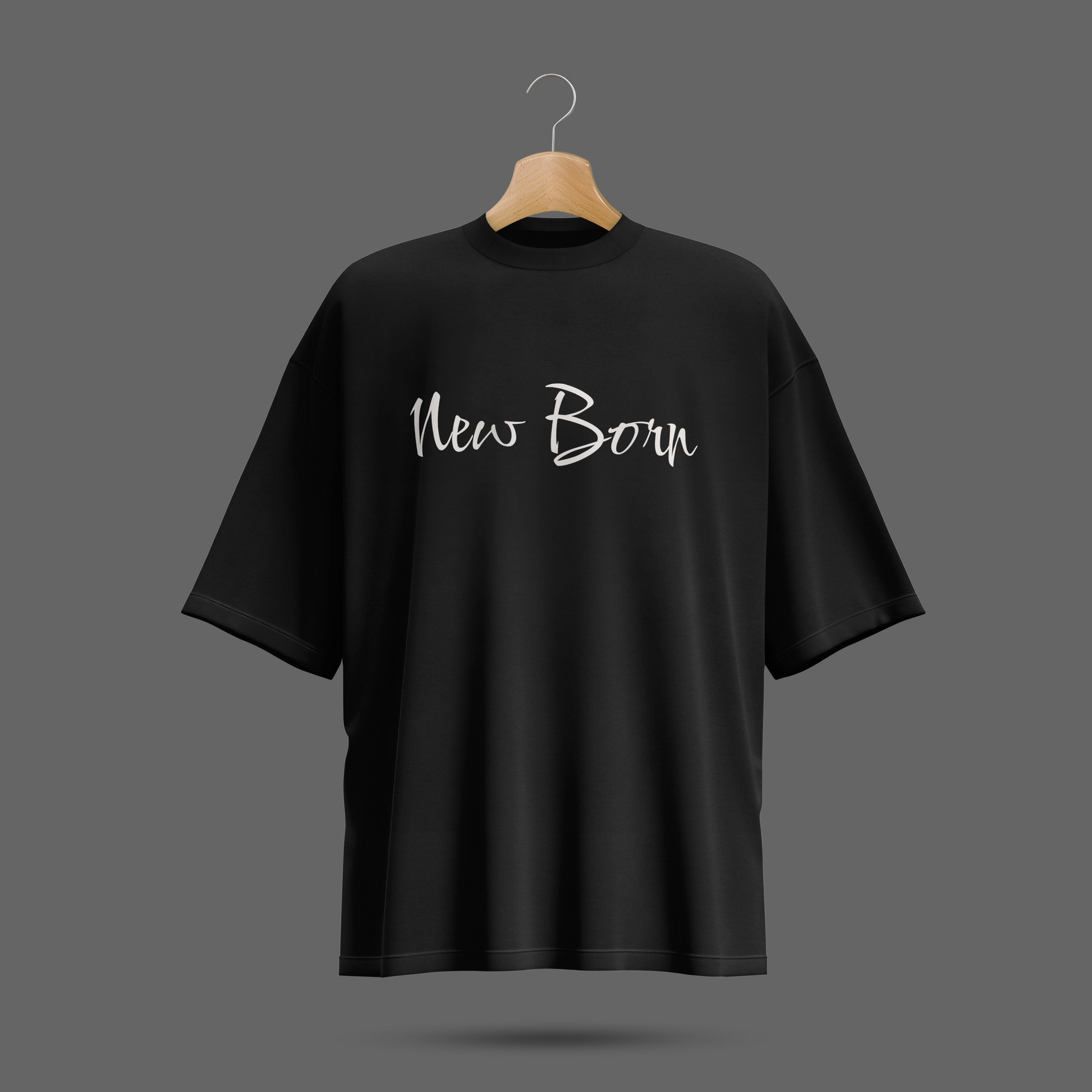 Black oversize t-shirt with 'New Born' text on a hanger against a dark background