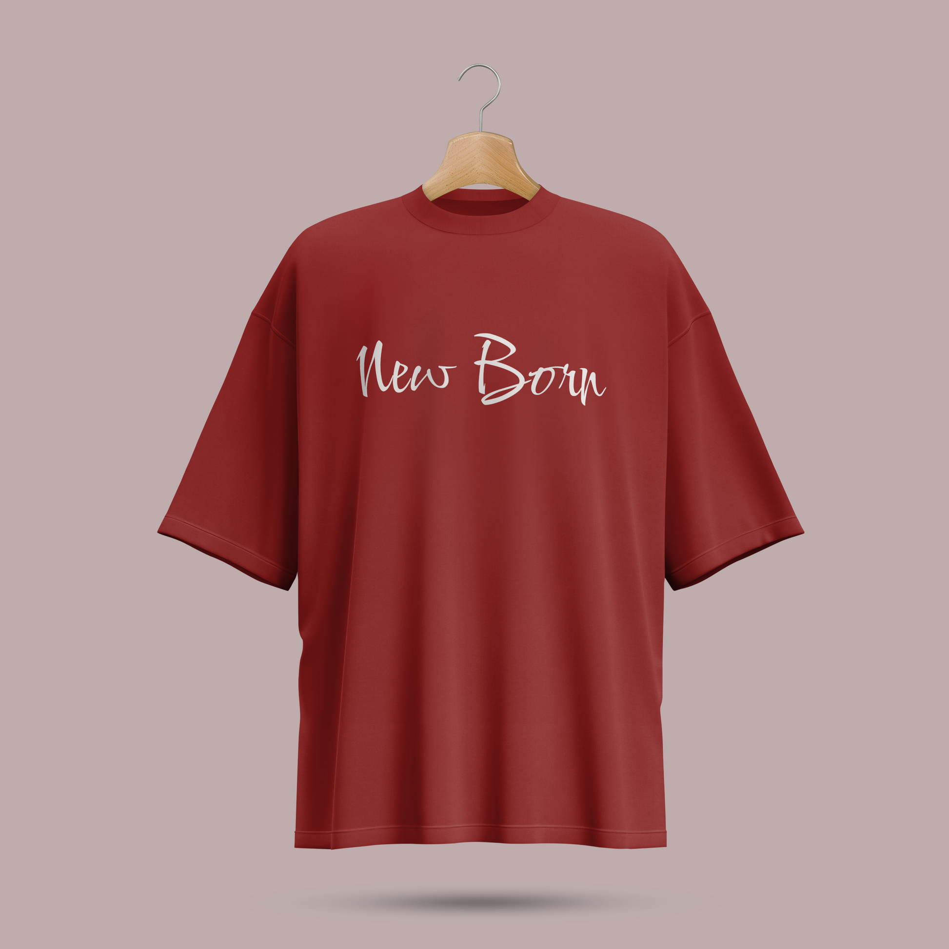 Red oversize t-shirt with 'New Born' text on a hanger against a beige background